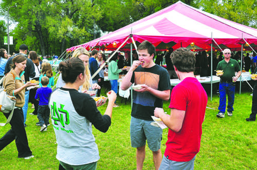 UND students Chloe Ree, Dylan Roness and Nick Wolterstorff eat french fries at the annual french fry feed at University Park during Potato Bowl week festivities. Photo by Daniel Yun/ The Dakota Student