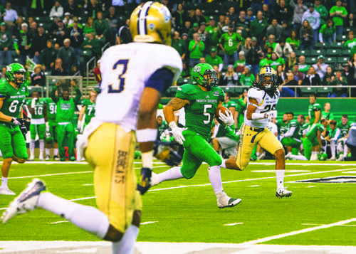 Brady Oliveira runs the ball against Montana State University during the Hall of Fame game at the Alerus Center last season. 
Photo by Nick Nelson/ The Dakota Student