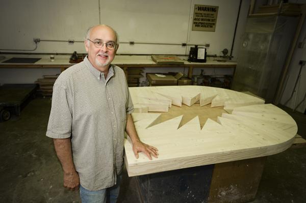 Patrick Luber and his newest creation that displays the connection between science and religion. Photo by Jackie Lorentz