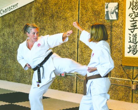 LaRoyce Batchelor demonstrates a kick with Karen Katrinak at the Hisshou Karate Dojo in Grand Forks, N.D. on Saturday, September 3, 2016. Photo by Daniel Yun/ The Dakota Student