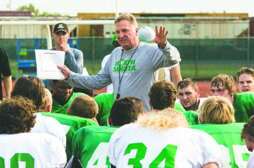 Head coach Bubba Schweigert addresses the football team after practice at Memorial Stadium in 2015.