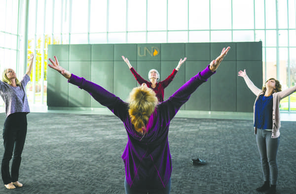 Kay Williams (front center) leads Ashley Watermolen (left), Marsy Schroeder (rear center) and Jessie Hoeger (right) in stretching during a Zen in 10 event at the Gorecki Alumni Center on Tuesday morning.