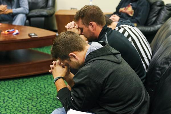 UND student athletes from the suspended baseball program (from left) Zach Heaser and Daniel Lockhert pray during a Fellowship of Christian Athletes (FCA) meeting Monday evening at the Betty Engelstad Sioux Center. FCA is represented by roughly thirteen athletic teams on campus, with the majority coming from women's basketball and softball.