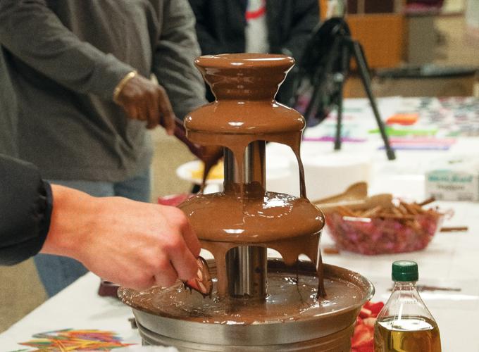 Students dip fruit into chocolate fondue duing Love Your Body week at the Memorial Union on Tuesday.