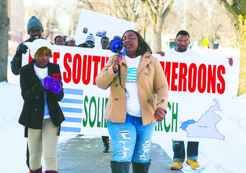 Elizabeth Nfor (center) leads students in a solidarity march on campus for Cameroon on Friday afternoon. Nick Nelson / Dakota Studenr