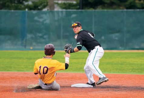 Former UND baseball player Ben Reznicek (right) tags out a University of Minnesota Crookston runner in the teams last season before the program was eliminated.