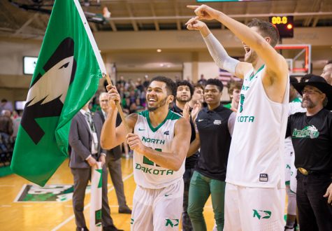 Quinton Hooker carries a flag bearing the UND Fighting Hawks logo around the Betty Engelstad Arena following the regular season Big Sky championship win over Portland State last Saturday.