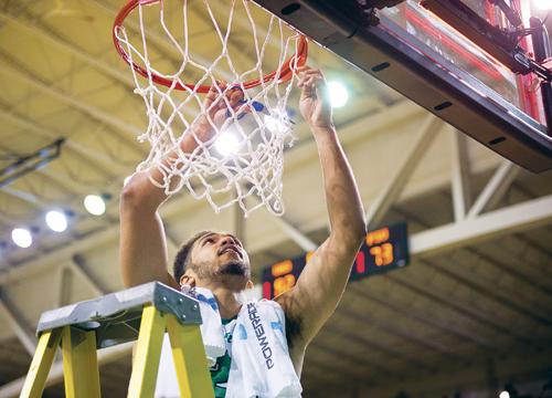 Senior guard Quinton Hooker cuts a piece of the net in celebration following Saturdays win against Portland State and UNDs Big Sky regular season championship. Nick Nelson/ Dakota Student