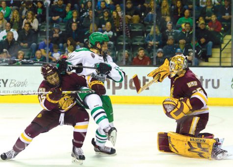 UND junior forward Austin Poganski is blocked by Minnesota Duluths Willie Raskob (left) as Poganski charges goalie Hunter Miska in a game earlier this season. Poganski was recently selected as team captain of the UND mens hockey team for the 2017-2018 season.