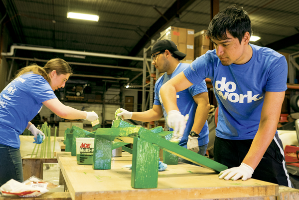 Zach Keo (right) paints flag pole stands with fellow Jonstone-Fulton Hall residents Michael Kelsh (center) and Grace Zeller (left) during the Big Event on Saturday morning.