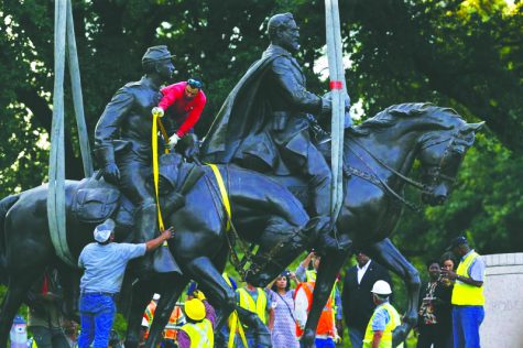 Workers prepare for the removal of a statue of Robert E. Lee at a public park in Dallas, Thursday, Sept. 14, 2017. In an unannounced move, a large crane was brought through the city by a police escort to Lee Park, where it lifted the large statue from its pedestal late Thursday afternoon. (Nathan Hunsinger/The Dallas Morning News via AP)