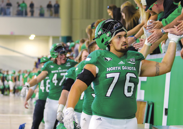 Fighting Hawks offensive lineman Dan Bell celebrates with fans following Saturdays Homecoming win over Northern Colorado.