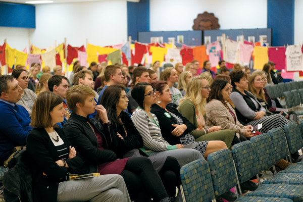 Audience members listen as Amber Flynn, sexual respect &amp; violence prevention coordinator at the UND Women's Center, speaks during the Take Back The Night rally on Monday night.