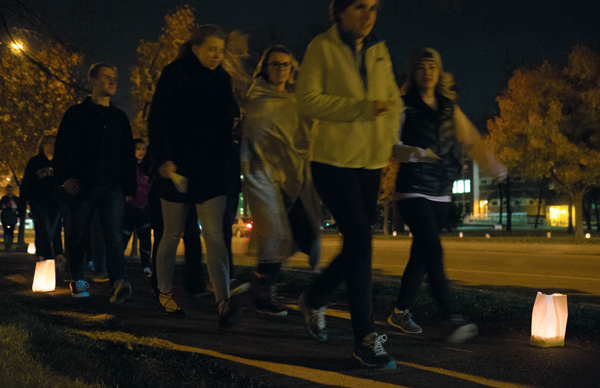 UND students, faculty, staff and community members march past luminaries on University Avenue during the Take Back The Night rally on Monday night.