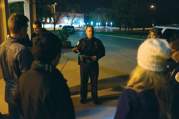 UND police chief Eric Plummer (center) assigns routes to groups during the fall campus safety tour outside Chester Fritz Auditorium on Thursday night.