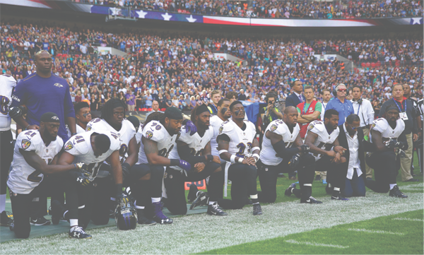 Players kneel on the Ravens sideline before the game in London versus the Jacksonville Jaguars. Joining the players was retired linebacker Ray Lewis, second from right. 