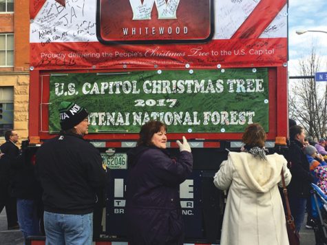 People sign a card accompanying the U.S. Capitol Christmas Tree during a stop in downtown Grand Forks on Sunday morning.