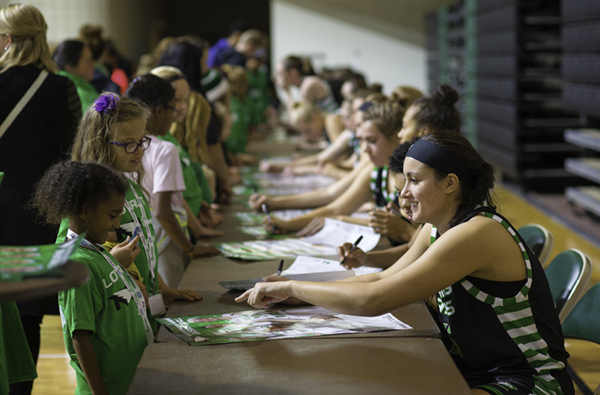Fighting Hawks forward Fallyn Freije signs her autograph for a young fan during Fan Fest at the Betty Engelstad Sioux Center this past fall.