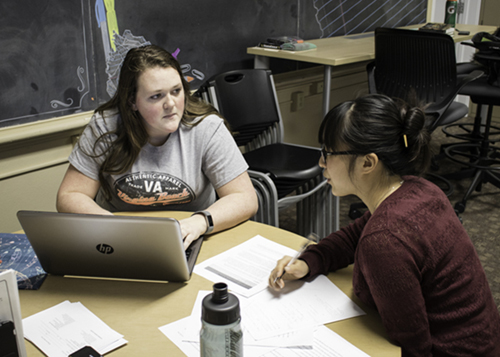 Ayla Rubenstein (right) assists Kaycie Ebert with a paper at the UND Writing Center in Merrifield Hall. 