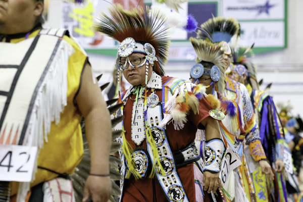 Dancers process through the Hyslop Sports Center during grand entry of the 48th annual Time Out Wacipi. 