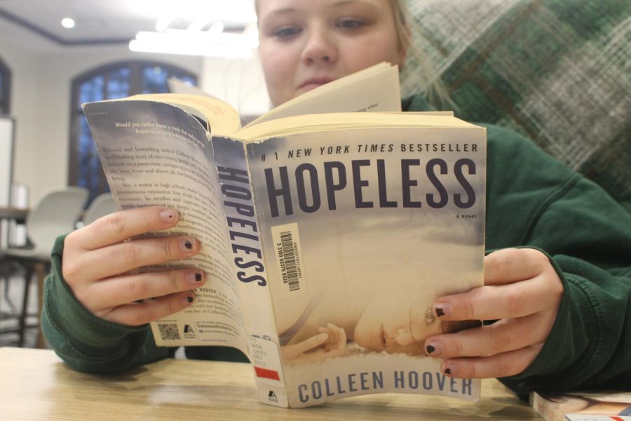 Woman reads book by Collen Hoover at the University of North Dakota Chester Fritz Library.