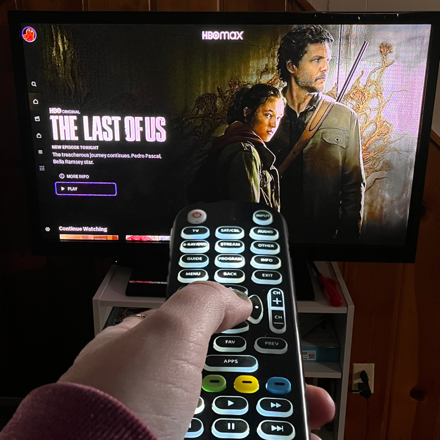 Hand holding remote in front of TV playing The Last of Us TV Show